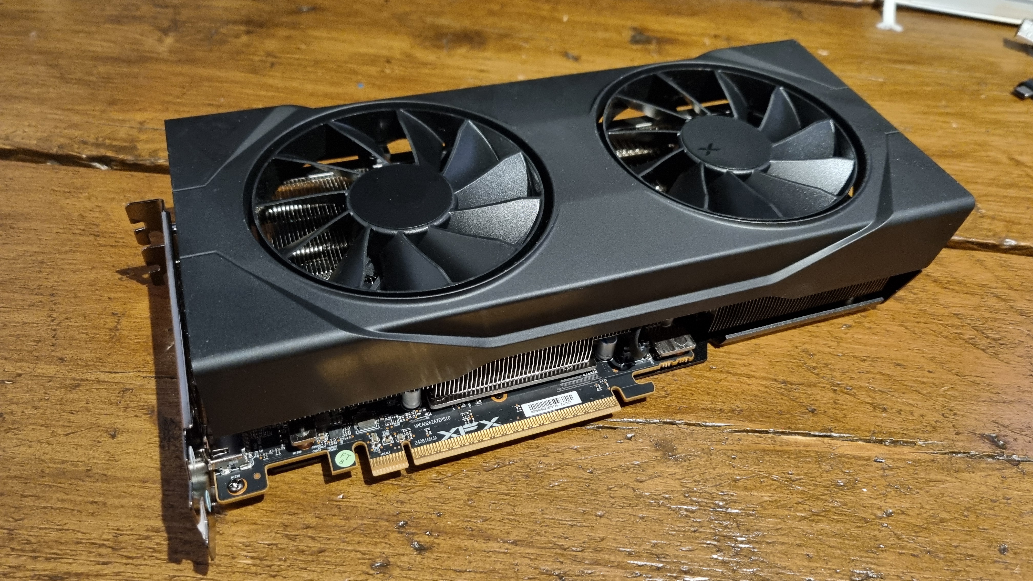 The XFX Swift RX 9060 XT on a wooden desk