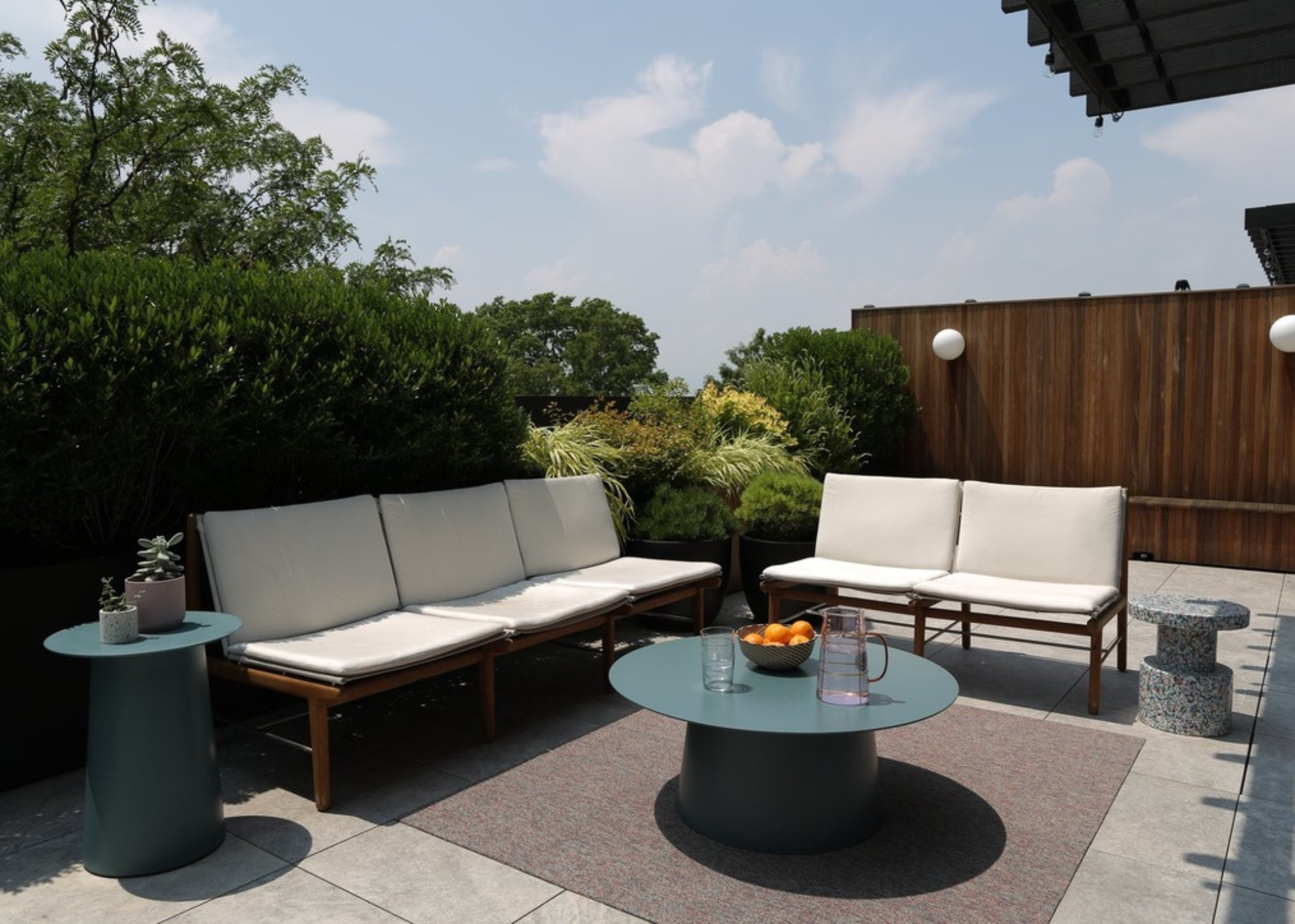 an urban garden patio with fencing and hedges and a seating area