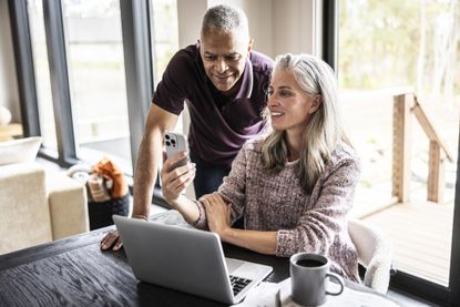 Couple using laptop and smartphone at home