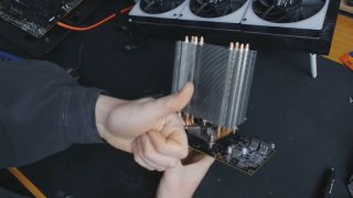 A CPU cooler on a GPU with a thumbs-up in front