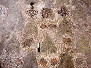 The mosaic floor includes images of birds and pomegranates, as well as leaf patterns.