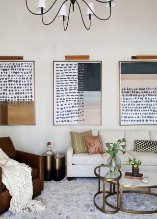 living room with white walls and large abstract art triptych on wall