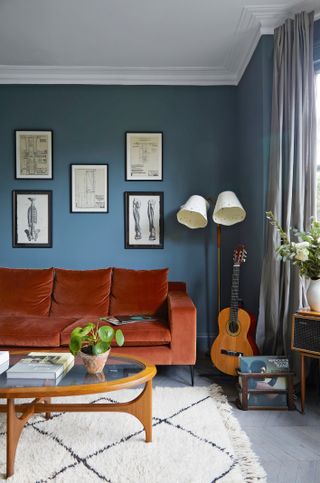 Blue living room with deep orange velvet sofa
