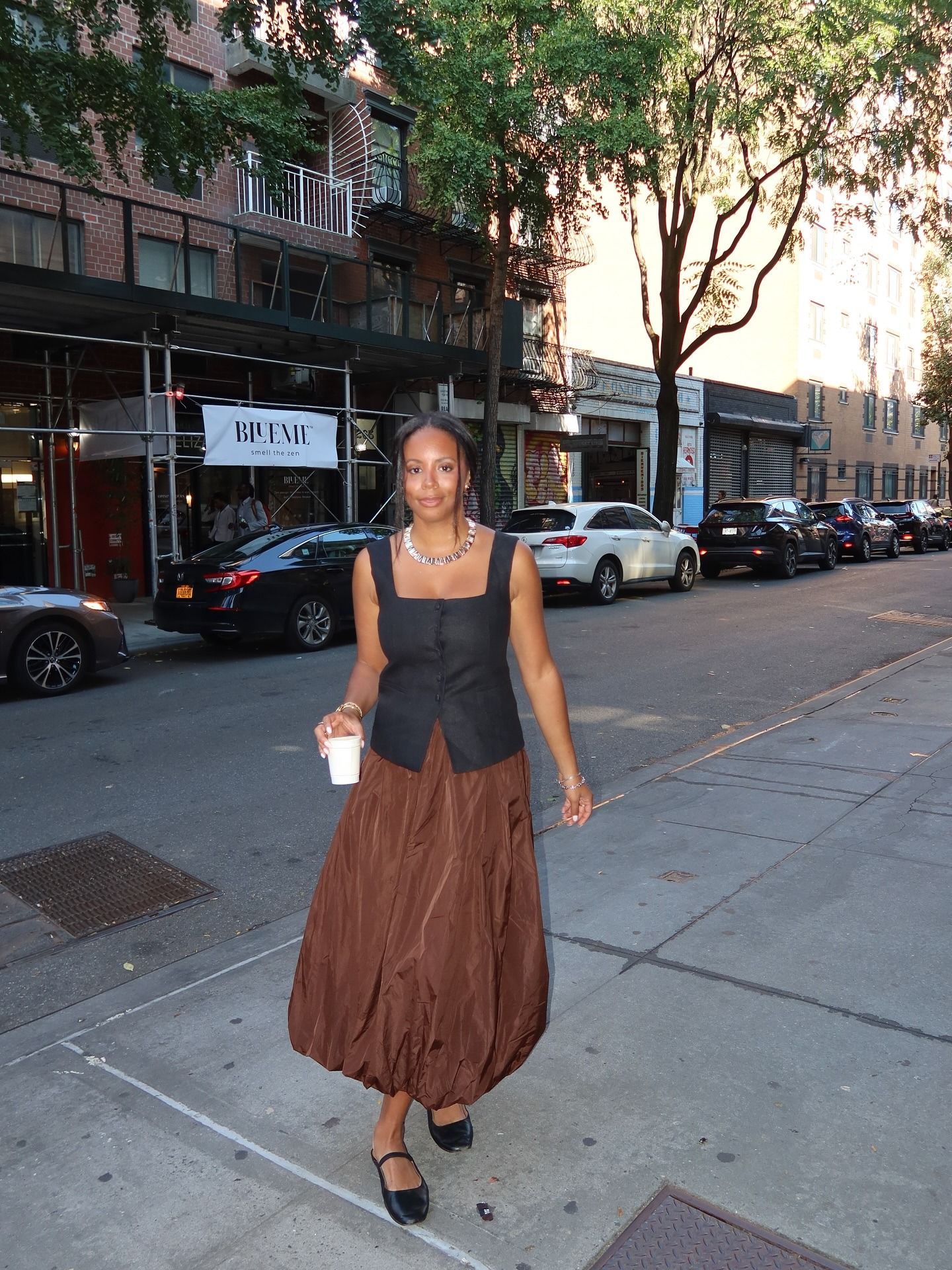 Who What Wear editor Sierra Mayhew in a brown bubble skirt and black button-up vest.