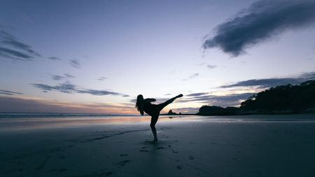 woman doing yoga on beach