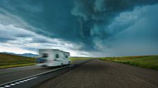 A motor home drives toward a storm.