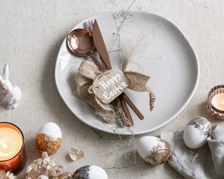 Rustic Easter place setting with molten metallic cutlery, natural textures, and metallic dipped eggs.