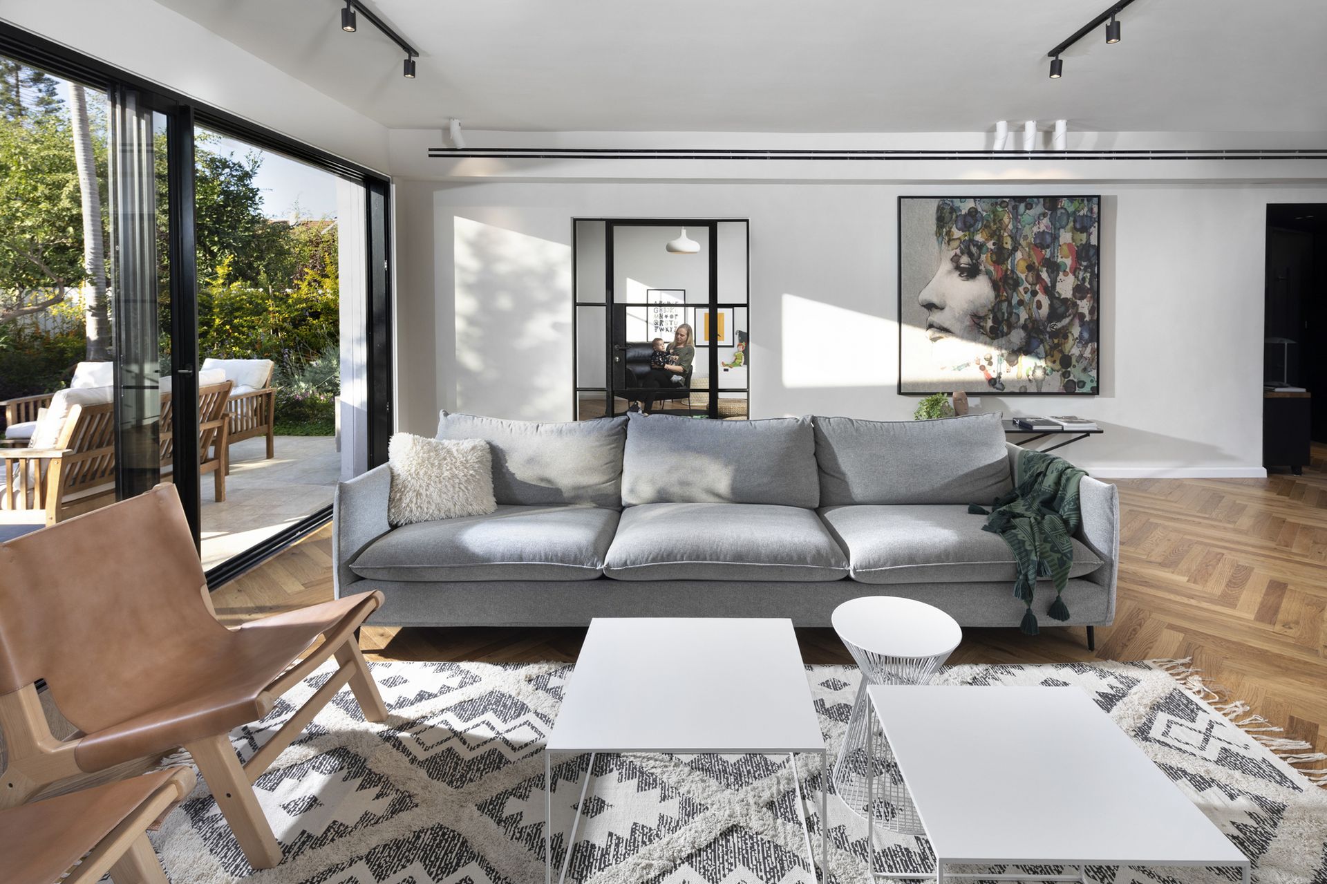 A grey living room with parquet flooring