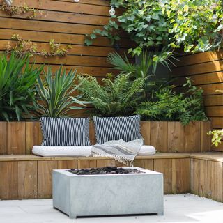 Patio area with built in seating, plants in the raised bed behind