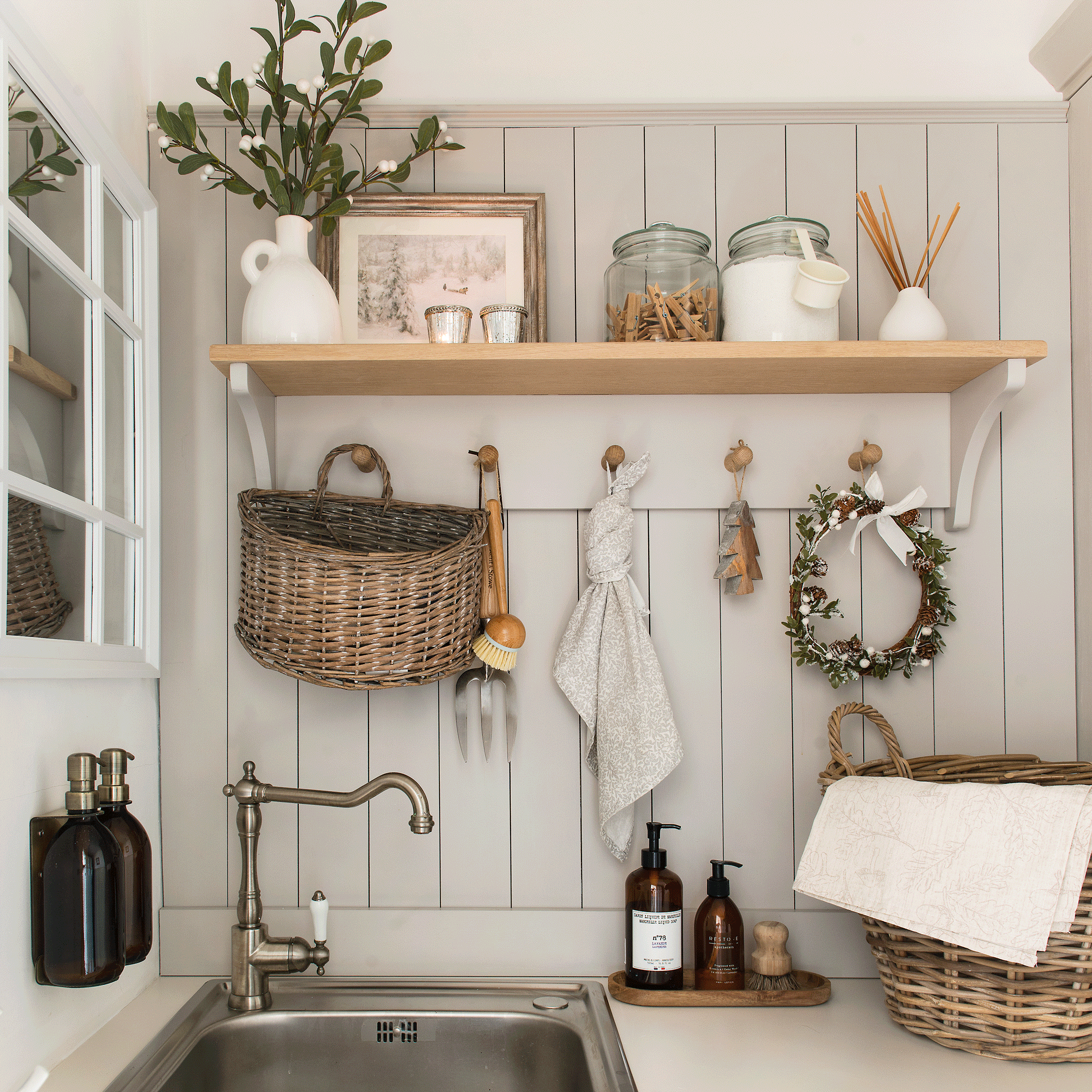 a utility area in a kitchen with a spare sink and a peg rail with baskets