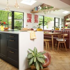 Open plan kitchen and dining area with a white kitchen island, black kitchen cabinets, and a dining room table