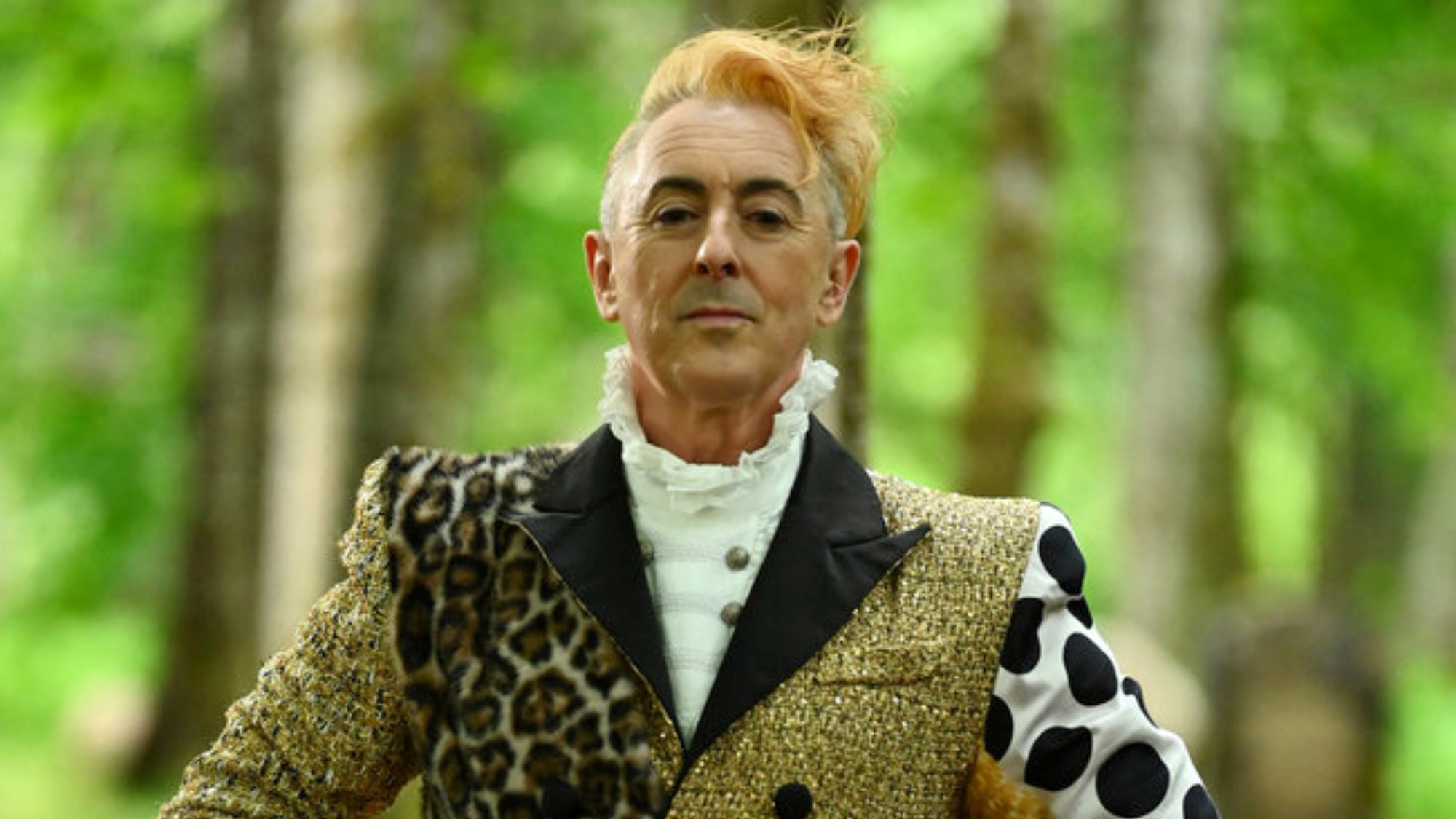 Alan Cumming hosting Season 4 of The Traiters while standing outside in the woods.