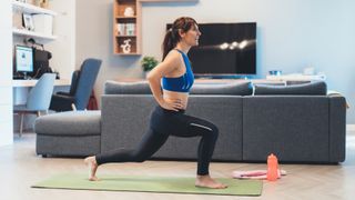 Woman performs lunges in her living room