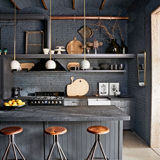 Black kitchen with hidden hanging extractor hood over a range cooker