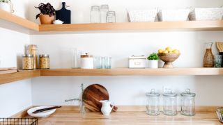 Open shelving with small kitchen storage solutions, including glass jars and canisters.
