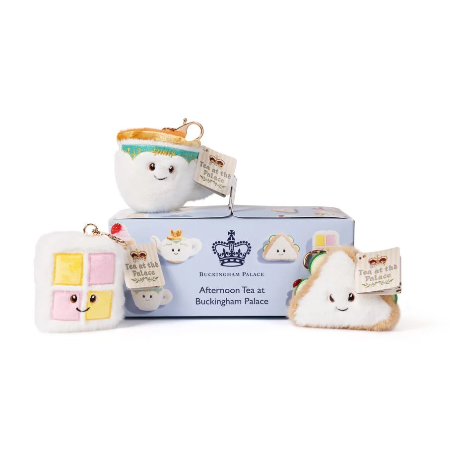 Royal Collection Trust Shop plushies including a pink and yellow battenberg cake slice cuddly keyring and a small toy sandwich and a cuddly white keyring cup with a box advertising Afternoon Tea