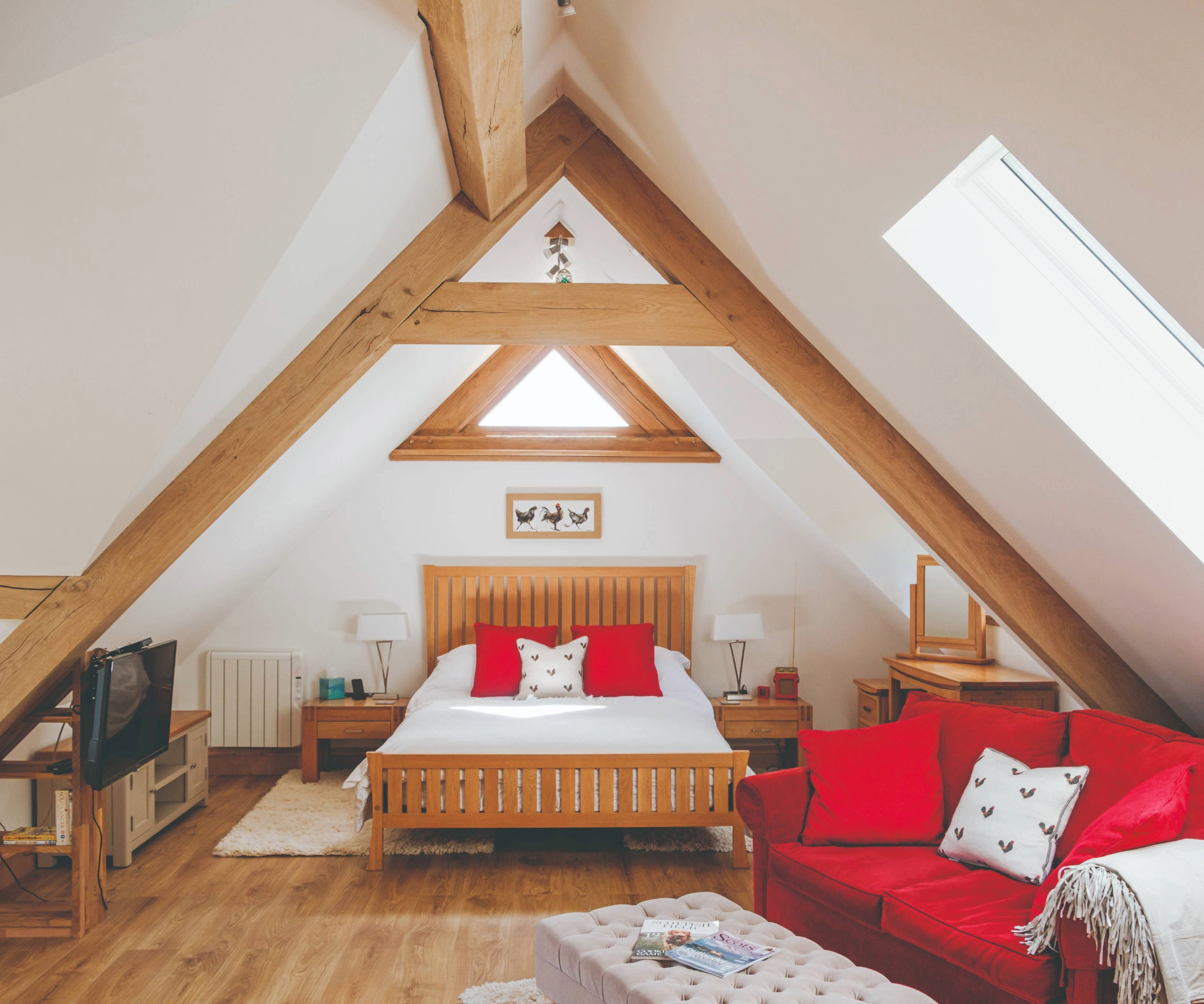 Inside the bedroom above the barn which features a red sofa