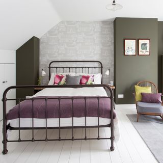 bedroom with grey wallpaper bed with designed cushion and white flooring