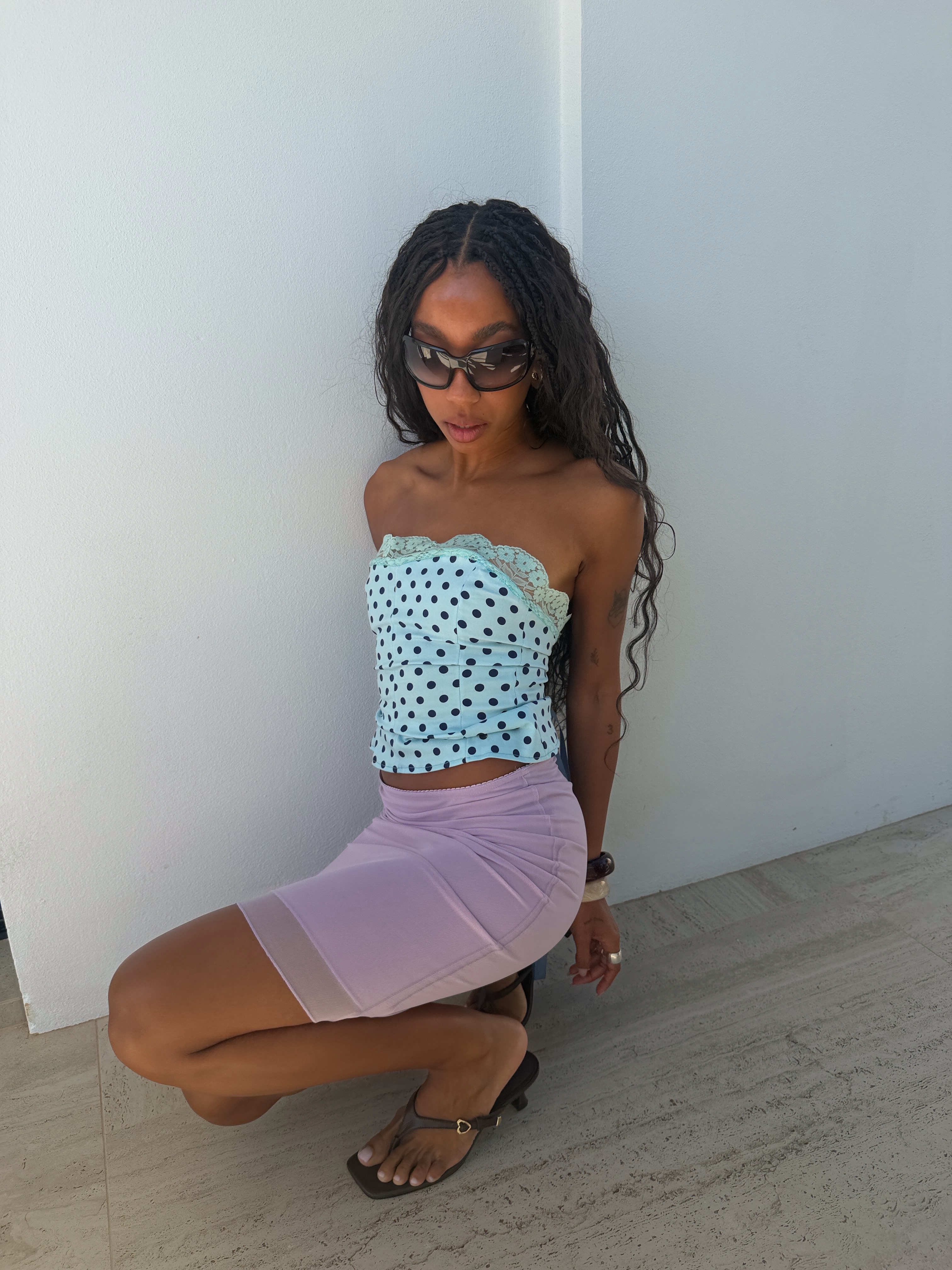 An image of a woman with a blue top and pink skirt on.
