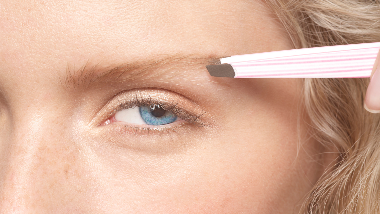 Best tweezers close up of a woman using tweezers to pluck her eyebrows