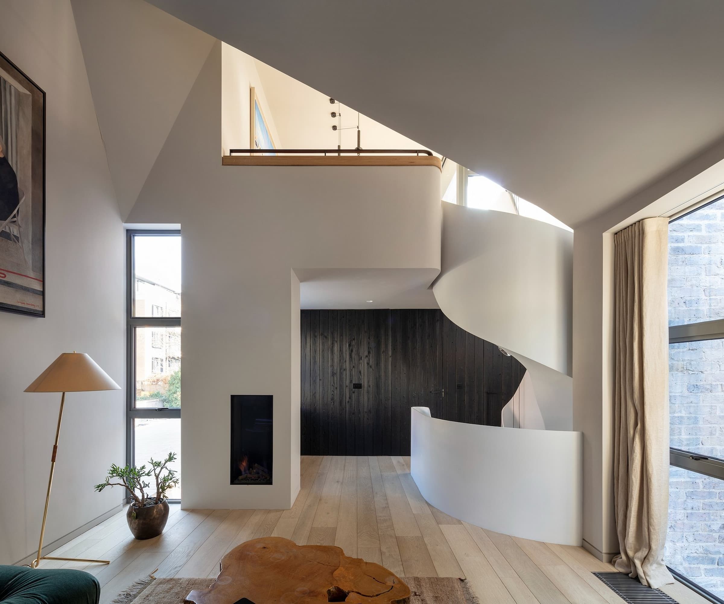 A white spiral staircase that leads to the third-floor of a townhouse