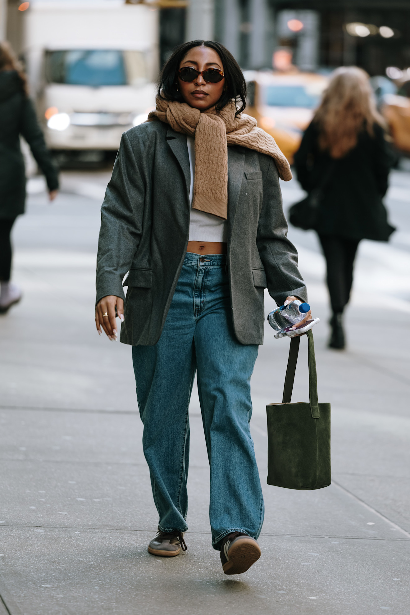 woman wearing cardigan, blazer, jeans, and sneakers
