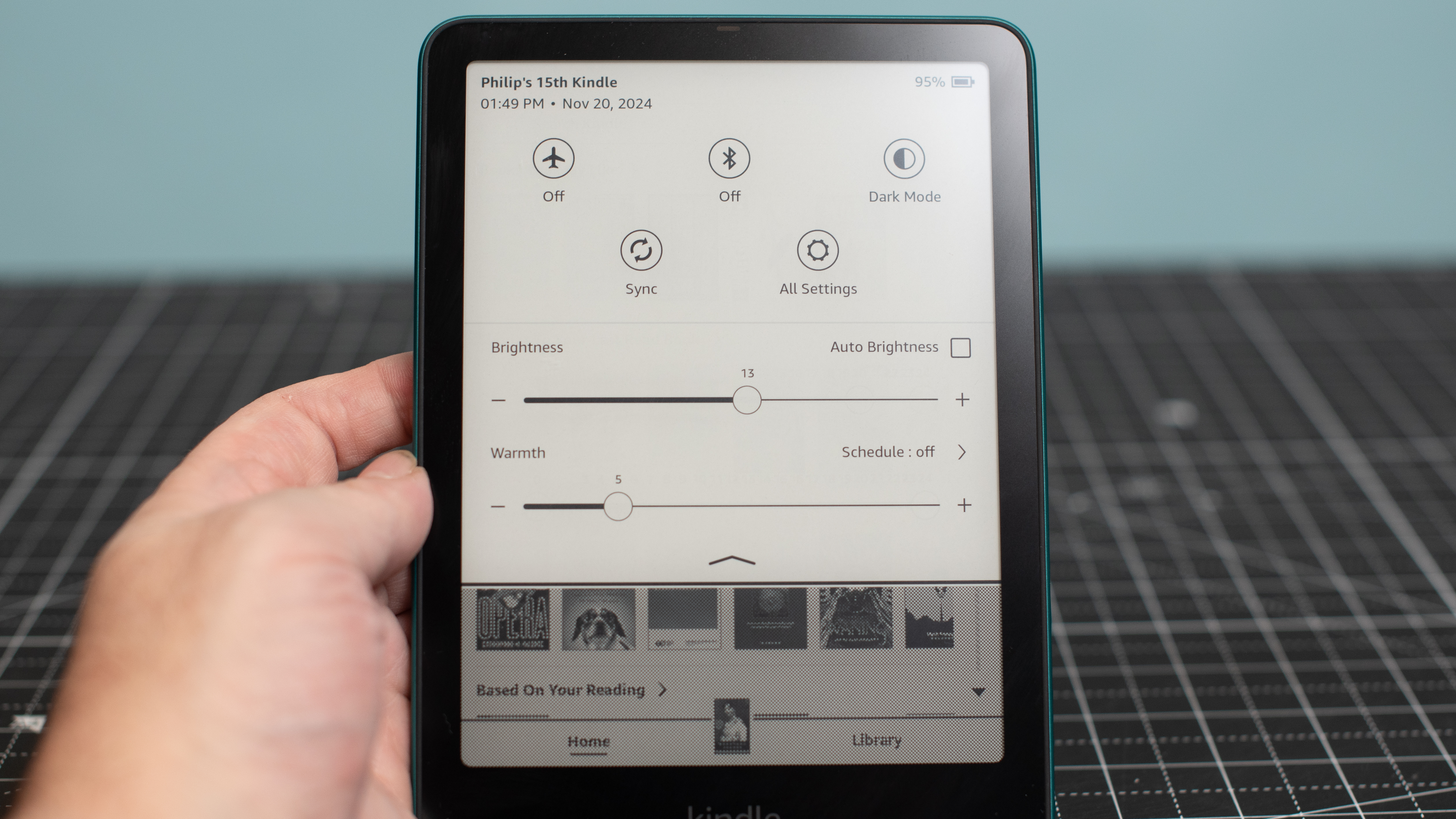 Kindle Paperwhite showing settings menu for screen brightness and warmth, Wi-Fi, Airplane mode, and more settings