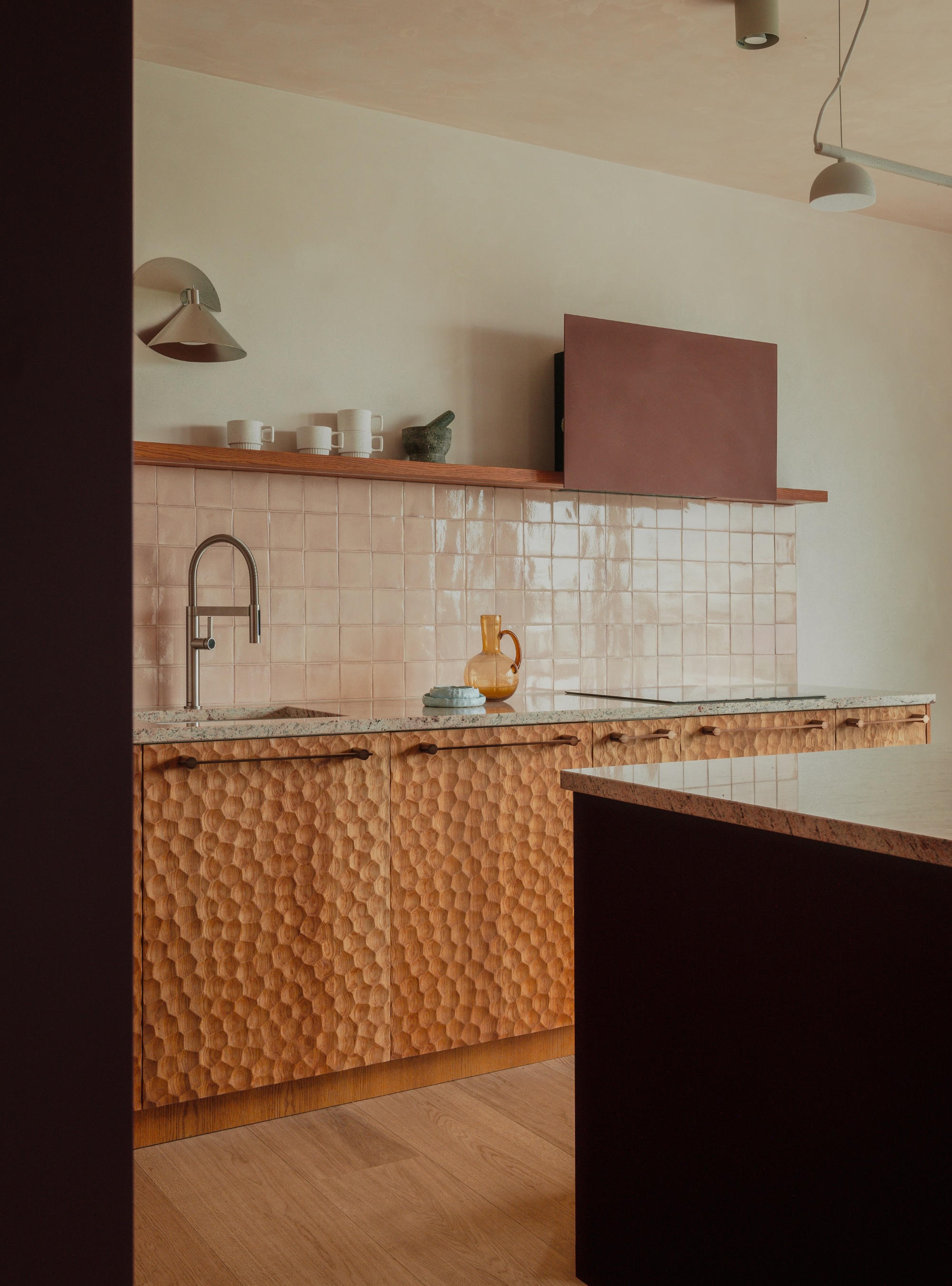 Kitchen with pink zellige splashback and etched wood cabinet doors