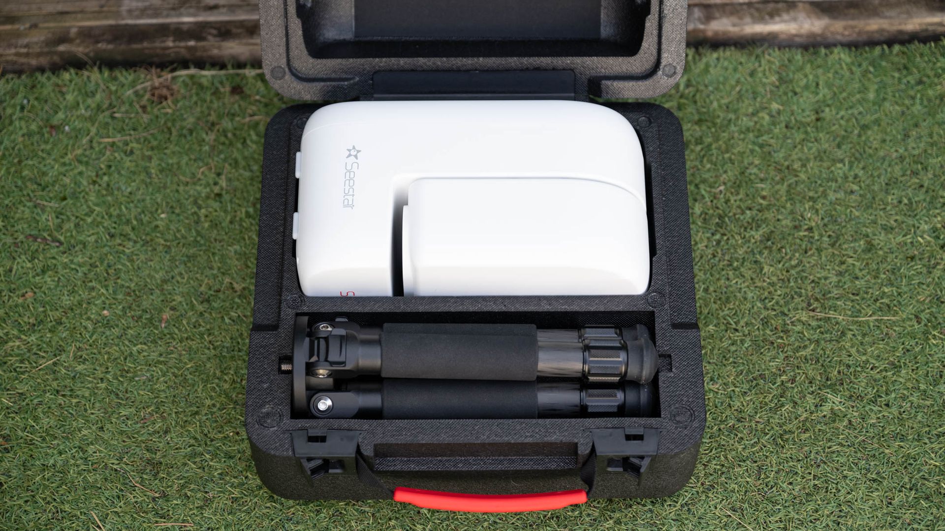 ZWO Seestar S50 Pro on a tripod against a green shed