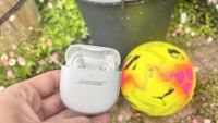 Bose QuietComfort Ultra Earbuds (2nd Gen) wireless earbuds next to a yellow football