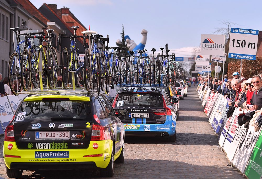 The race race caravan makes its way over the cobbles at Nokere Koerse