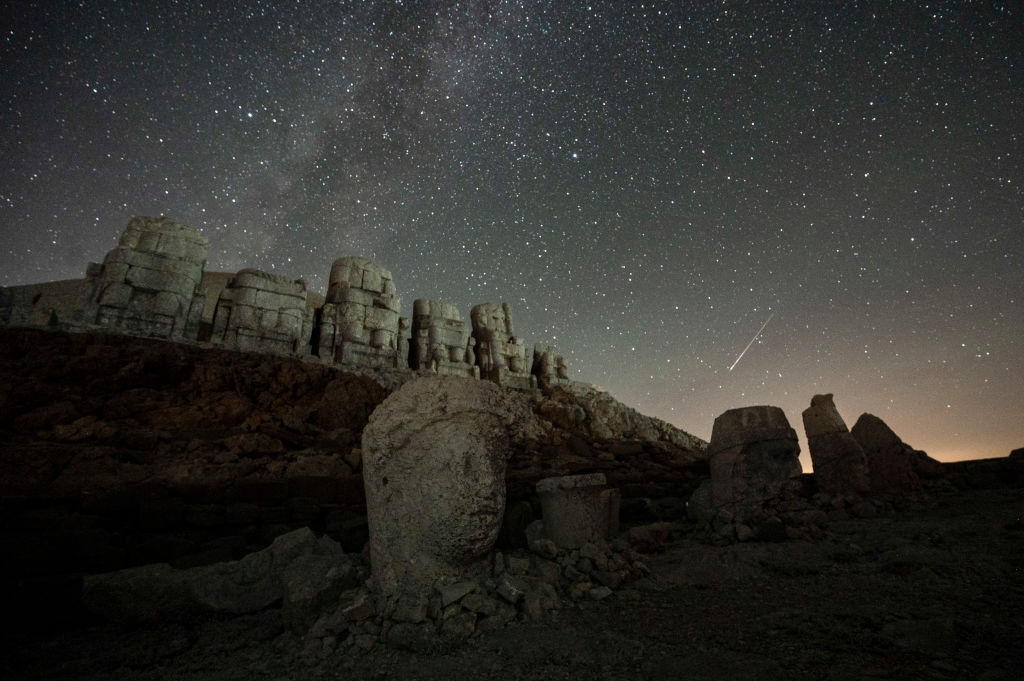 Bu fotoğraf, Türkiye'nin güneydoğusunda, Adıyaman'daki Nemrut Dağı arkeolojik alanında devasa taş kafa oymalarını göstermektedir.