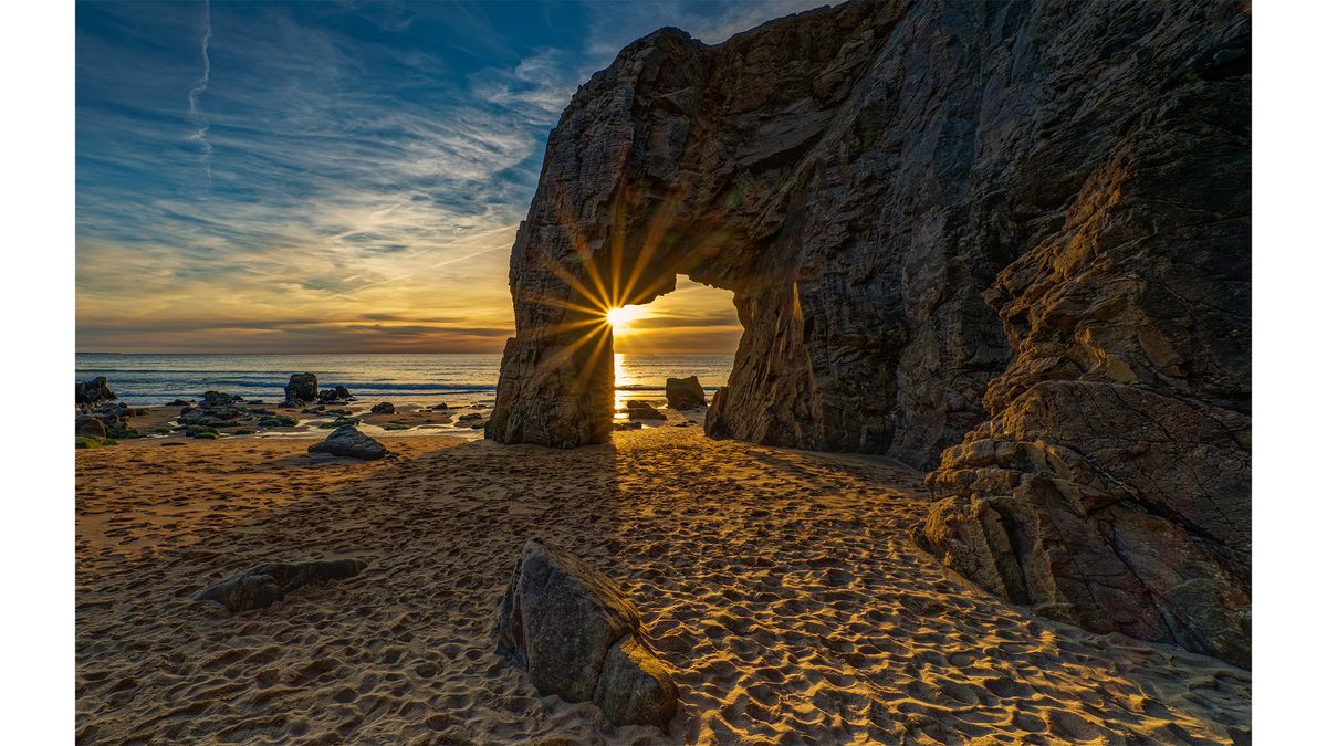 The arch of Port Blanc on the Brittany coast with a starburst.