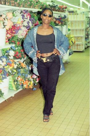 African woman standing posing in a supermarket