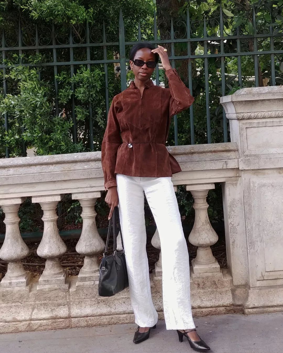 Sylvie Mus wearing a brown suede jacket with white pants.