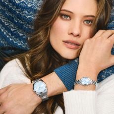 Woman wearing Bulova watch and holding man's arm