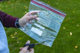 Cutting a plastic bag to make a camera rain cover