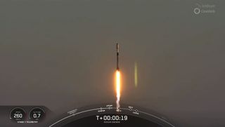 A SpaceX Falcon 9 rocket rises into the morning sky on a pillar of flame