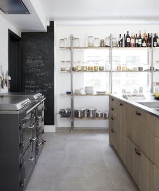 Gray stone kitchen flooring ideas example with a black aga and open chrome shelving.