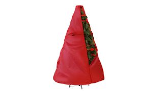 An upright Christmas tree partially zipped inside a red storage bag, for the best Christmas tree storage bags.