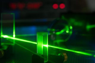 An experiment involving a green laser that aims to show photons can behave as both a particle and a wave