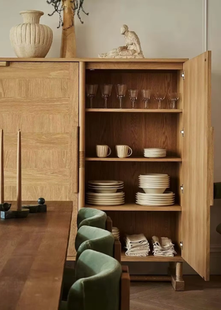 A hosting closet with plates, mugs, goblets and napkins