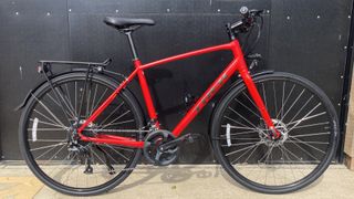 A red Trek FX 2 Disc Equipped pictured in front of a black door