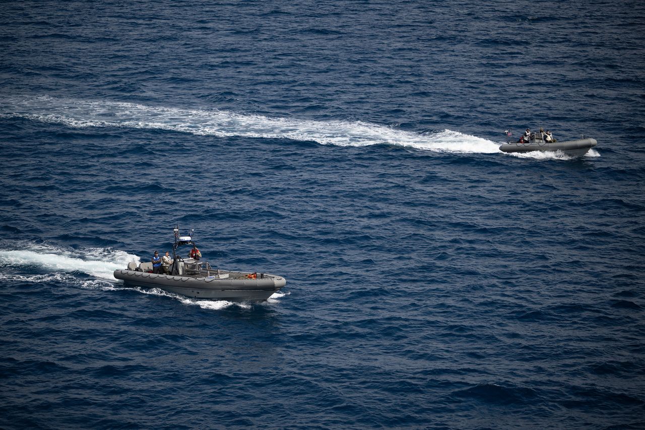 Small boats travel to the Orion capsule as part of Artemis 2 recovery efforts.