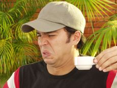 A man cringes after drinking something bad-tasting