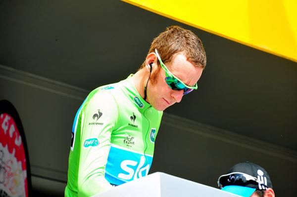 Bradley Wiggins (Sky), wearing the green points leader's jersey, signs on for stage 1.