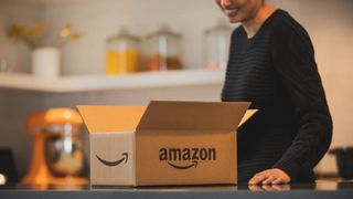 Woman opening Amazon Prime box in kitchen