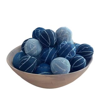 A brown bowl of blue denim balls