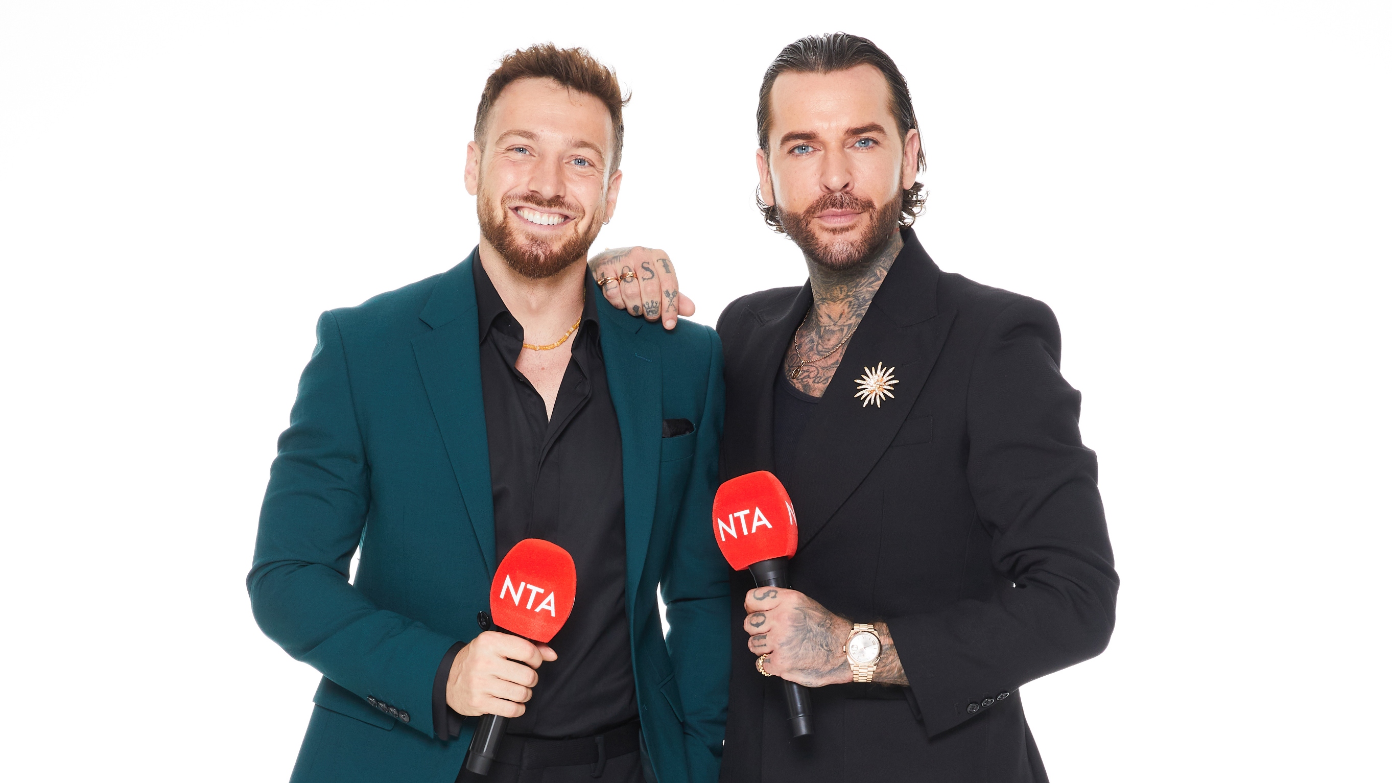 Red carpet hosts Sam Thompson and Pete Wicks in suits and holding red microphones