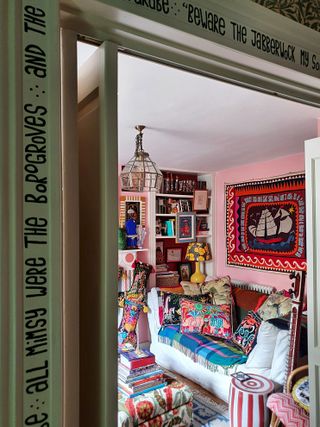 colorful hallway with handpainted doorframe and double doors into colorful living room full of embroidered artwork